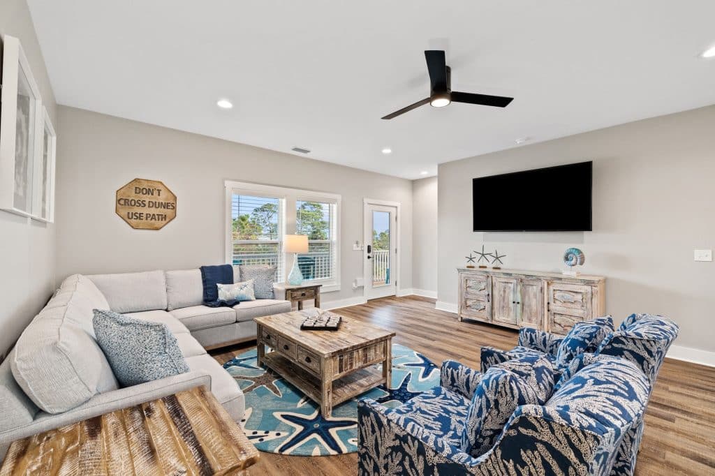 coastal designed open floor plan living room with beachy white and floral furniture and accessories designed and decorated by Shore House Furniture in Panama City Beach Florida
