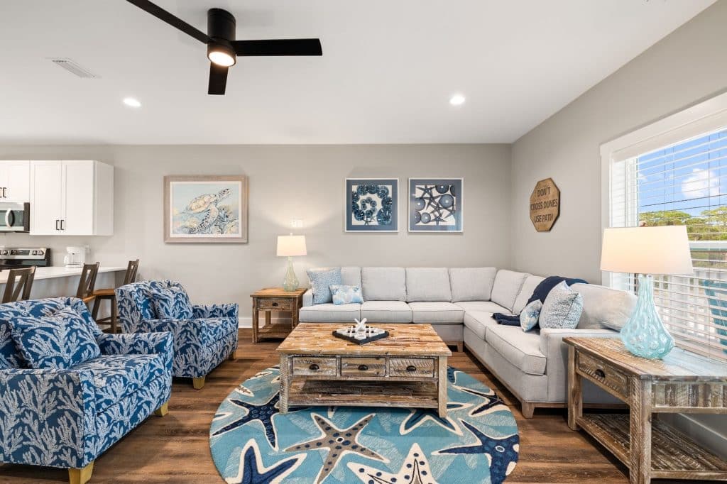 coastal designed open floor plan living room with beachy white and floral furniture and accessories designed and decorated by Shore House Furniture in Panama City Beach Florida