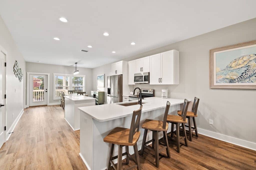 coastal designed open kitchen and breakfast bar with beachy white and blue furniture and accessories designed and decorated by Shore House Furniture in Panama City Beach Florida