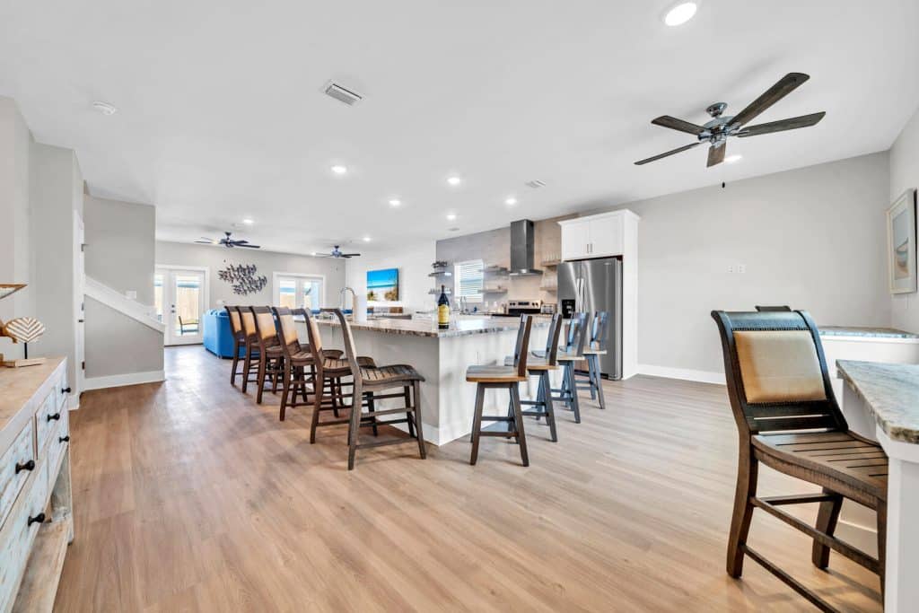 coastal designed open floor plan kitchen and breakfast bar with beachy white and dark blue accessories designed and decorated by Shore House Furniture in Panama City Beach Florida