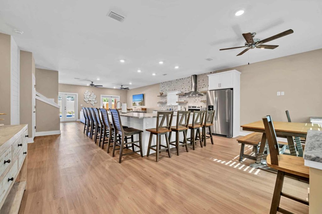 coastal designed open floor plan kitchen and bar with beachy white and blue accessories designed and decorated by Shore House Furniture in Panama City Beach Florida