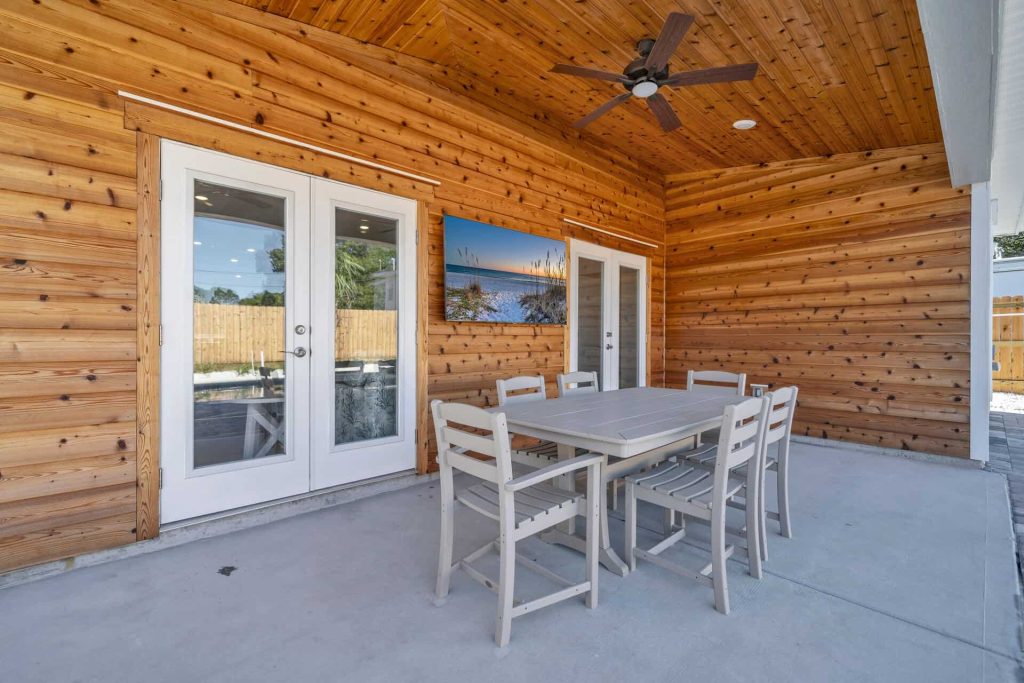 coastal designed outdoor pool and patio area with beachy accessories designed and decorated by Shore House Furniture in Panama City Beach Florida