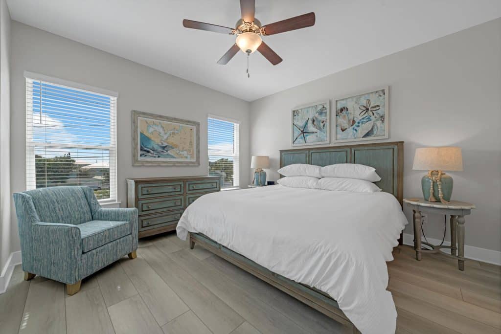 coastal designed master bedroom with beachy white and teal accessories designed and decorated by Shore House Furniture in Panama City Beach Florida