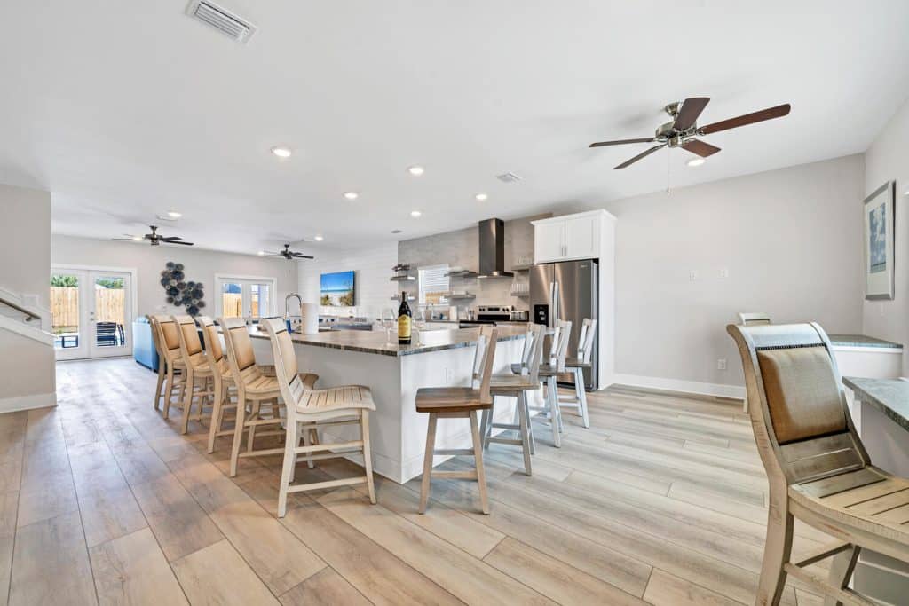 coastal designed open floor plan kitchen and breakfast bar with beachy white and dark blue accessories designed and decorated by Shore House Furniture in Panama City Beach Florida