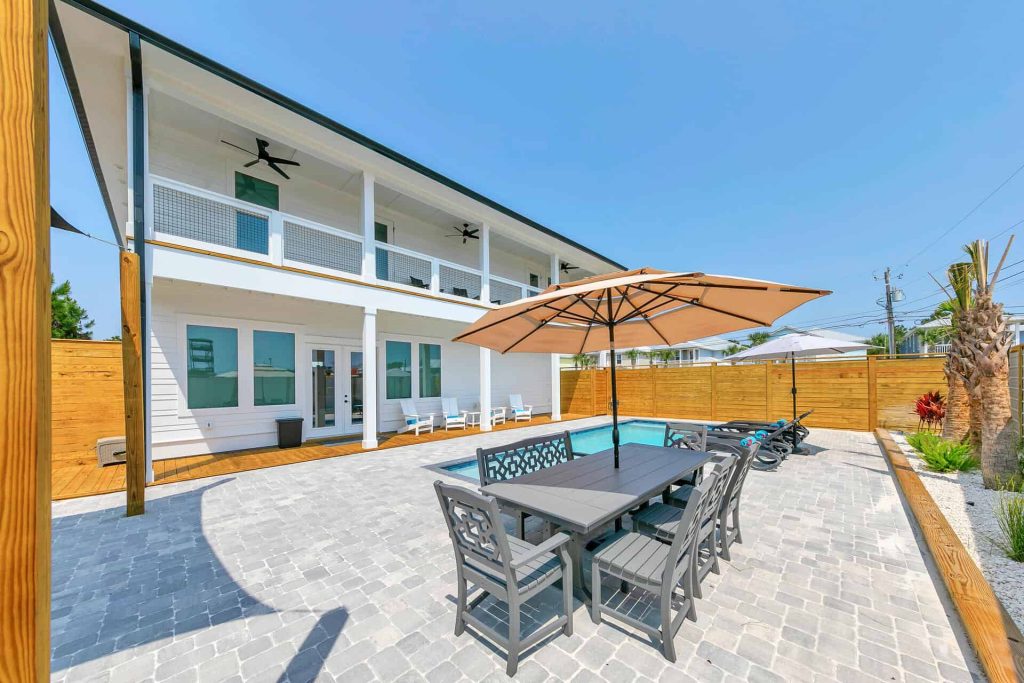 coastal designed outdoor pool and patio area with beachy accessories designed and decorated by Shore House Furniture in Panama City Beach Florida