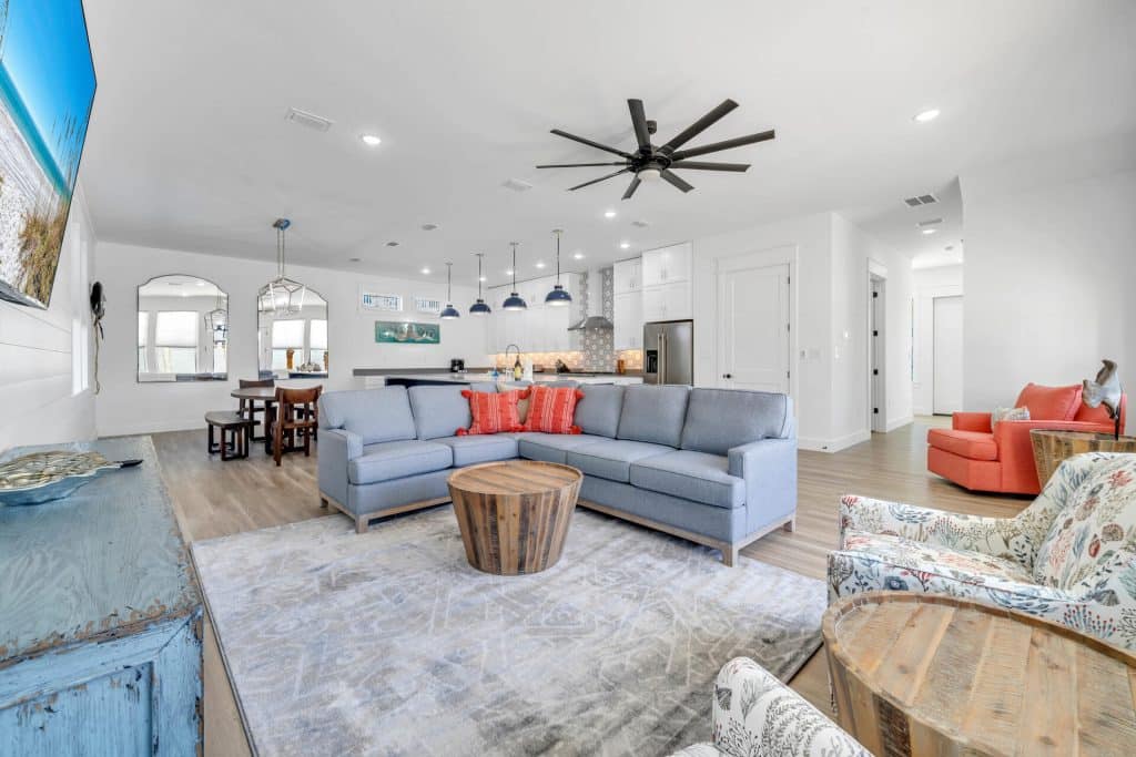 coastal designed living dining and kitchen area open floor plan with beachy white and blues accessories designed and decorated by Shore House Furniture in Panama City Beach Florida