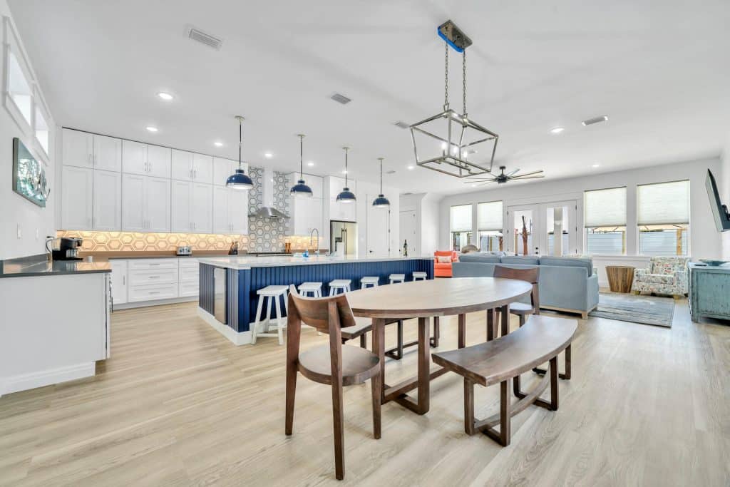 coastal designed living dining and kitchen area open floor plan with beachy white and blues accessories designed and decorated by Shore House Furniture in Panama City Beach Florida